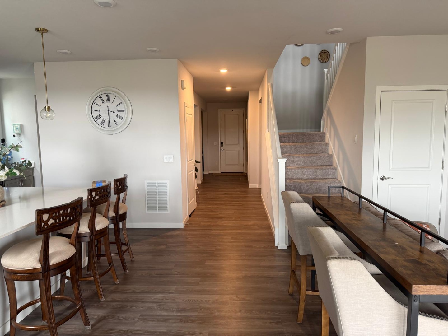 Kitchen wall with cabinetry, stainless refrigerator, oven stack, and island seating