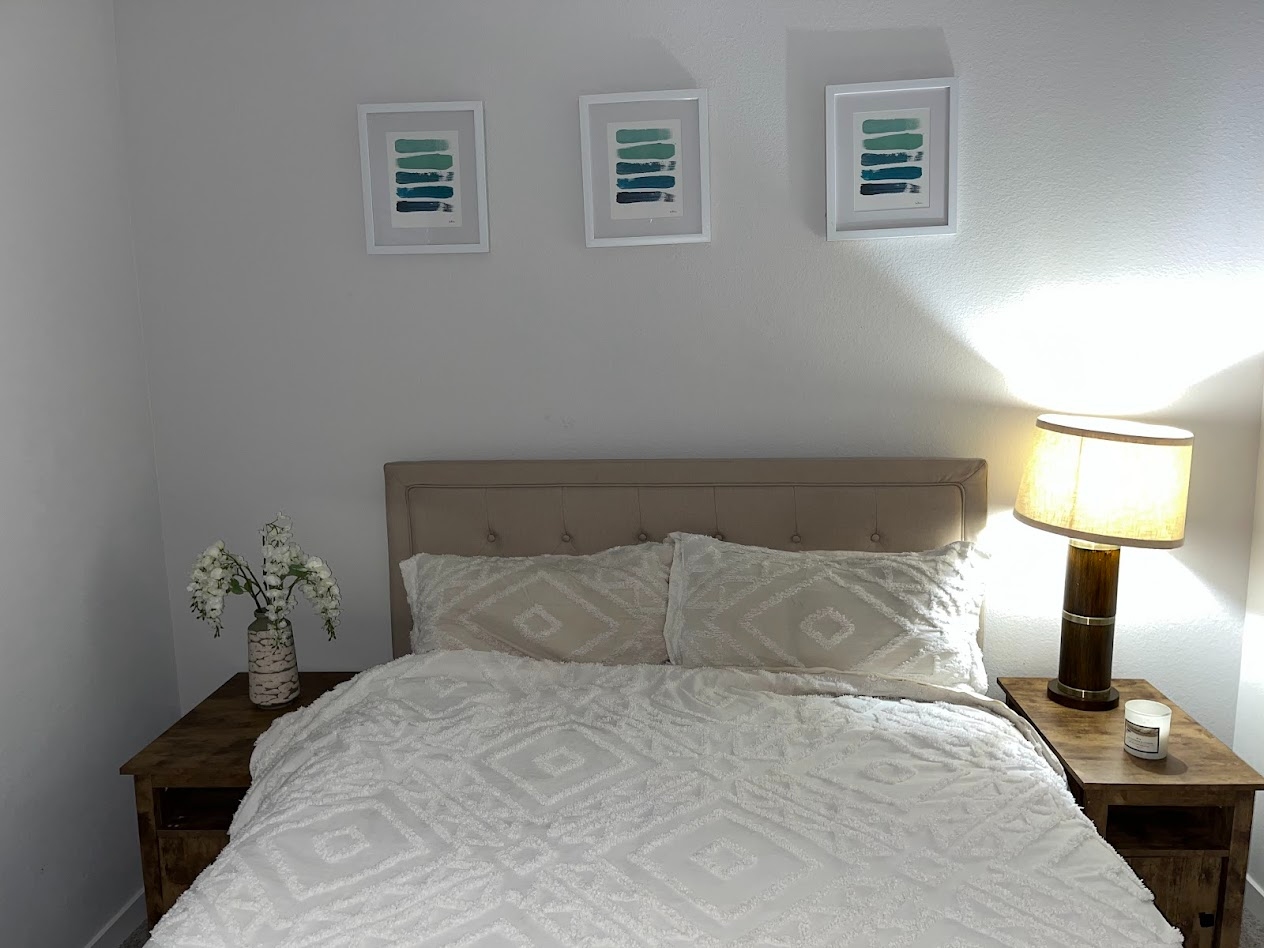 Ground-floor bedroom staged with white bedding and wood nightstands
